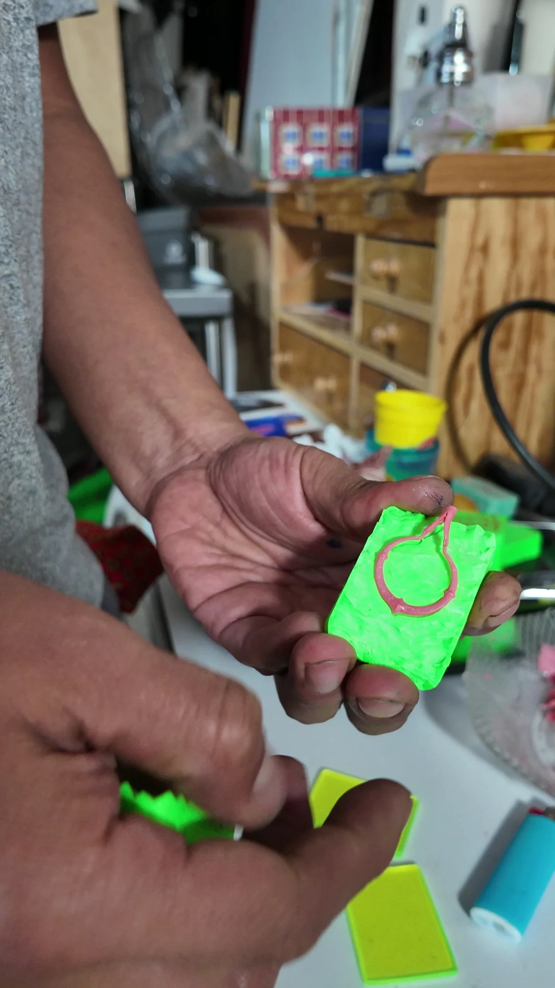 A castable earring model revealed in a green mould.