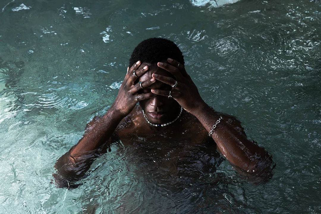 A man wearing jewellery standing in the water at Tolantongo